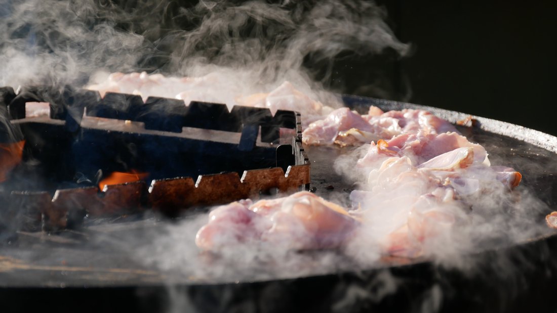 Rook boven de barbecue tijdens het grillen